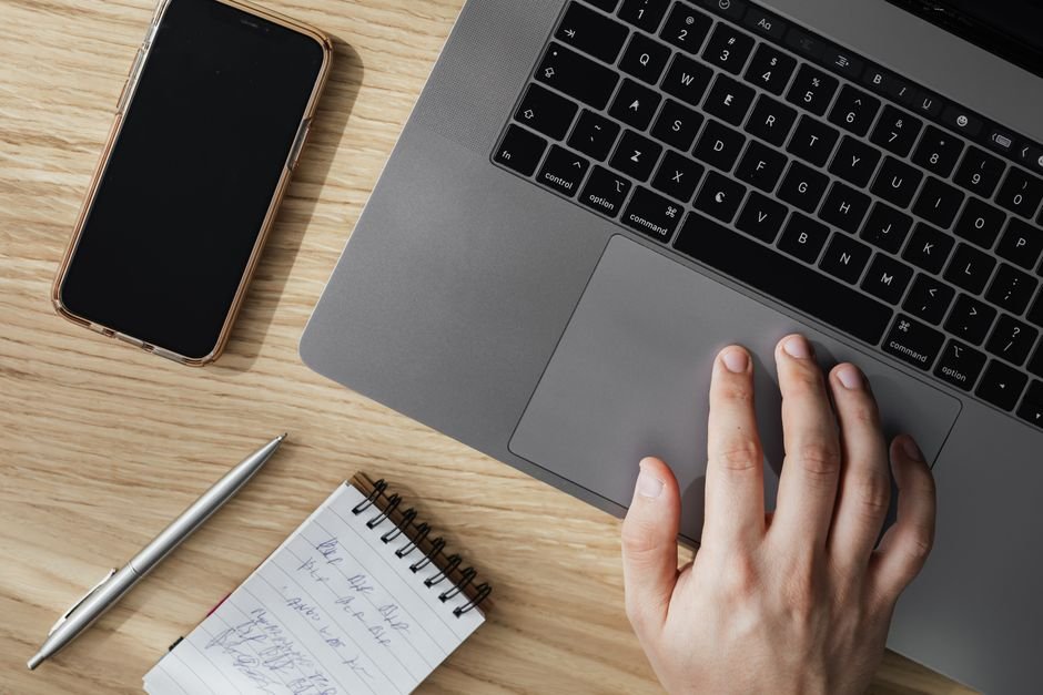 Professional using the best AI tools for productivity on a laptop with notes