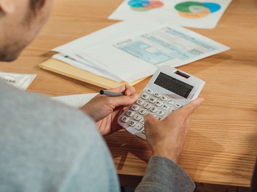 Person comparing old vs new tax regime salary examples with a calculator and documents